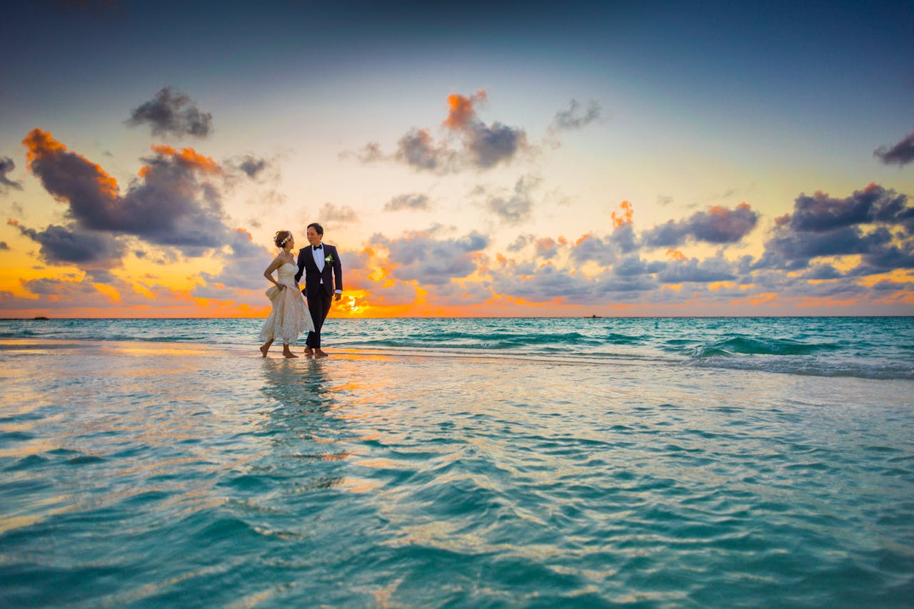 pexels-photo-1024993 A young couple enjoying a romantic beach wedding during a vibrant sunset.